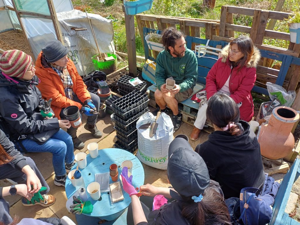 Volunteers eating and drinking together after planting seeds at the Community Garden. 